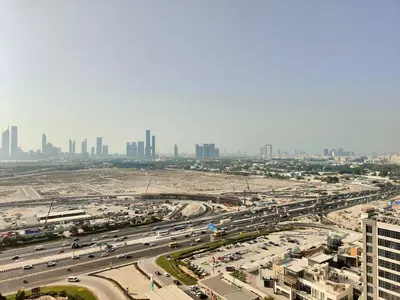 an aerial view of a highway with a city in the background at Cozy Modern 1BR with Dubai Skyline View in Dubai