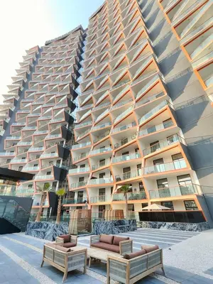 a large apartment building with two benches in front of it at Cozy Modern 1BR with Dubai Skyline View in Dubai