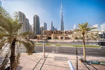 a view of a city with palm trees and a street at Full Burj View - Souk vibe one-bedroom apartment in Dubai