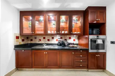 a kitchen with wooden cabinets and a sink at Full Burj View - Souk vibe one-bedroom apartment in Dubai