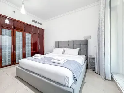 a bedroom with a large bed with two towels on it at Opal Tower Condos - Dubai Marina in Dubai