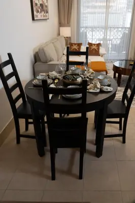 a black dining room table with chairs and a couch at Sleep 5 Near Dubai Mall in Dubai