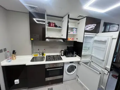 a small kitchen with a sink and a washing machine at Studio in Business Bay with Huge Balcony & Pool View near to Metro in Dubai