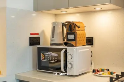 a microwave on top of a counter in a kitchen at Luxury 1BR in Sobha Hartland w Pool & Gym Access in Dubai