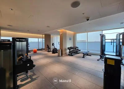 an empty gym with a view of the ocean at Luxury 1BR in Sobha Hartland w Pool & Gym Access in Dubai