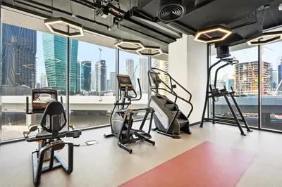 a gym with cardio equipment and a view of the city at New, Bright & Cozy 1BD at Paragon by IGO, Dubai in Dubai