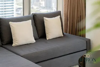 a gray couch with two white pillows on it at The Lavish Suite in Dubai
