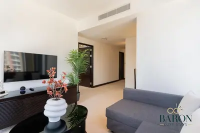 a living room with a couch and a tv at The Lavish Suite in Dubai