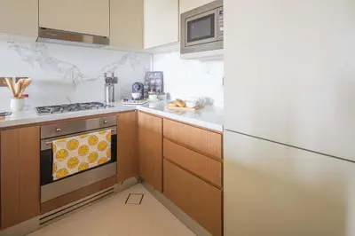 a kitchen with wooden cabinets and a stove at Frank Porter - Address Opera Tower in Dubai