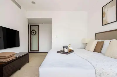 a bedroom with a large white bed and a television at Frank Porter - Marina Mall Hotel in Dubai