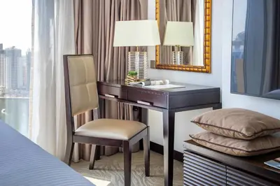 a bedroom with a desk with a chair and a mirror at Frank Porter - Marina Mall Hotel in Dubai
