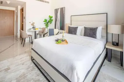 a bedroom with a large white bed with a tray on it at Frank Porter - Azizi Riviera 51, Meydan in Dubai