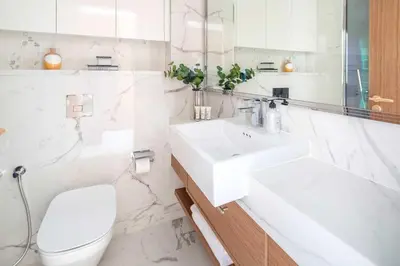 a white bathroom with a sink and a toilet at Frank Porter - Azizi Riviera 51, Meydan in Dubai