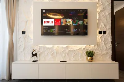 a tv on top of a white cabinet in a room at Premium 1BR Stay with Balcony & City View, Nad Al Sheba in Dubai
