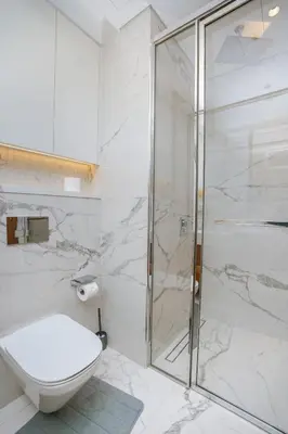 a white bathroom with a shower and a toilet at NEW! Studio in Azizi Riviera 59 in Dubai