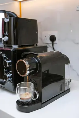 a coffee maker is making a cup of coffee at NEW! Studio in Azizi Riviera 59 in Dubai