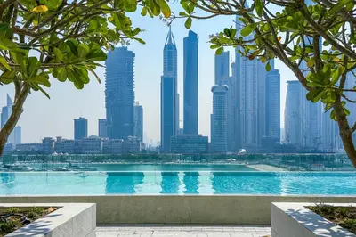 a swimming pool with a city skyline in the background at Luxury 3BR plus Maids Room in Emaar Beachfront in Dubai