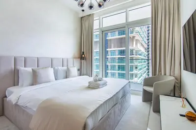 a bedroom with a large bed and a large window at Luxury 3BR plus Maids Room in Emaar Beachfront in Dubai