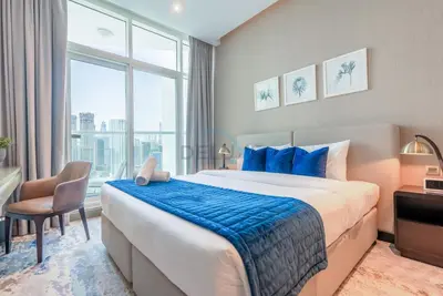 a bedroom with a large bed and a large window at Full Canal Views, Minutes from Downtown and Burj Khalifa, Close to Metro Station - Prive By Damac B, Business Bay by Deluxe Holiday Homes in Dubai