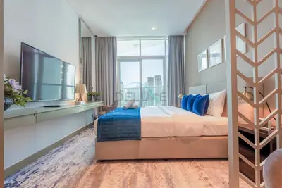 a bedroom with a large bed and a tv at Full Canal Views, Minutes from Downtown and Burj Khalifa, Close to Metro Station - Prive By Damac B, Business Bay by Deluxe Holiday Homes in Dubai