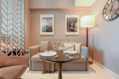 a living room with a table and chairs at Full Canal Views, Minutes from Downtown and Burj Khalifa, Close to Metro Station - Prive By Damac B, Business Bay by Deluxe Holiday Homes in Dubai