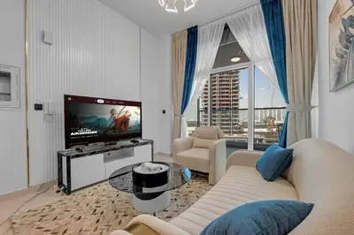 a living room with a couch and a tv at Opal by Danube | Designer 1BR | Private Jacuzz in Dubai