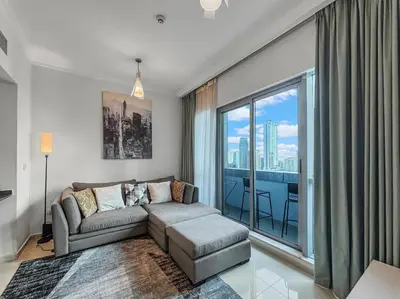 a living room with a couch and a large window at 2204 DXB Marina, KingBed, Steps to Tram, Clubs & Dining, Bay Central in Dubai