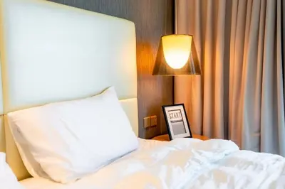 a bedroom with a bed with a pillow and a lamp at Exquisite 1BR at DAMAC Paramount Tower D in Dubai