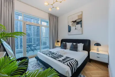 a bedroom with a bed and a large window at ShoresInn - Luxe Waterfront in Heart of Marina in Dubai