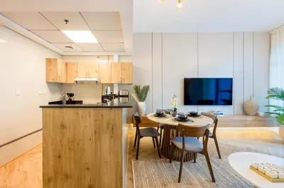 a kitchen and dining room with a table and a kitchen and a living room at ShoresInn - Luxe Waterfront in Heart of Marina in Dubai
