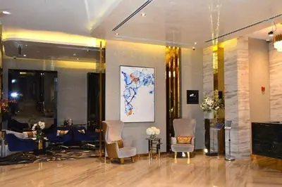 a lobby with chairs and tables and a painting on the wall at Premium Studio Majestine by DAMAC, Business Hub in Dubai