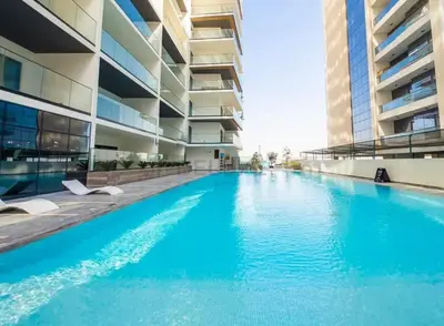 a swimming pool in front of a building at Creek Harbour Views 1BR, Just Minutes from Ras Al Khor Wildlife Sanctuary and Short Stroll to Zabeel Stadium, Binghatti Creek, Al Jaddaf by Deluxe Holiday Homes in Dubai