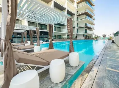 a swimming pool with chaise lounge chairs next to a building at Creek Harbour Views 1BR, Just Minutes from Ras Al Khor Wildlife Sanctuary and Short Stroll to Zabeel Stadium, Binghatti Creek, Al Jaddaf by Deluxe Holiday Homes in Dubai