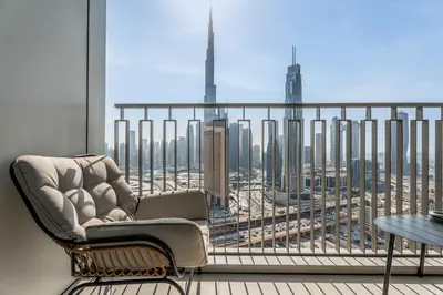 a chair on a balcony with a view of a city at Luxury 3 bed with Burj Khalifa and Dubai Skyline View in Dubai
