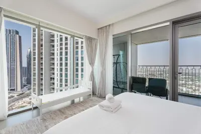 a bedroom with a large white bed and large windows at Luxury 3 bed with Burj Khalifa and Dubai Skyline View in Dubai