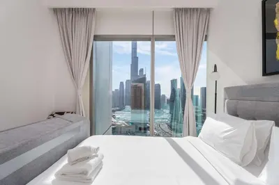 a white bedroom with a view of a city at Luxury 3 bed with Burj Khalifa and Dubai Skyline View in Dubai