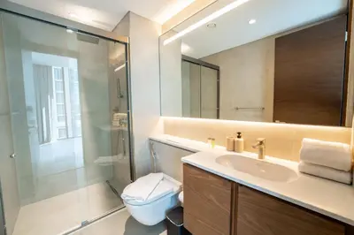 a bathroom with a sink and a toilet and a mirror at EasyGo - Stylish 2BR With City View in Sobha Creek in Dubai