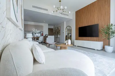a living room with a white couch and a tv at Nasma Luxury stays- Luxury-highfloor-iconic location in Dubai
