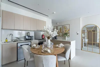 a kitchen with a table and chairs in a kitchen at Nasma Luxury stays- Luxury-highfloor-iconic location in Dubai