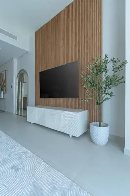 a living room with a television on a wooden wall at Nasma Luxury stays- Luxury-highfloor-iconic location in Dubai