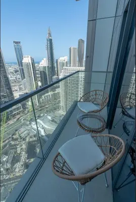 a balcony with chairs and tables on top of a building at Nasma Luxury stays- Luxury-highfloor-iconic location in Dubai