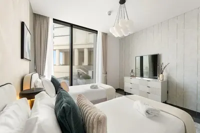 a living room with two beds and a tv at FIRST CLASS 3BR Stylish Luxury Escape in Dubai