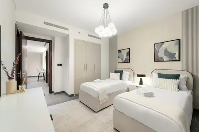 a bedroom with two beds and a living room at FIRST CLASS 3BR Stylish Luxury Escape in Dubai