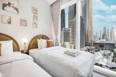 two beds in a room with a view of a city at Forte 4BR Luxury Dubai Opera & BLVD Views PS5 in Dubai