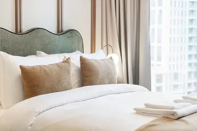 a bedroom with a white bed with a large window at Forte 4BR Luxury Dubai Opera & BLVD Views PS5 in Dubai