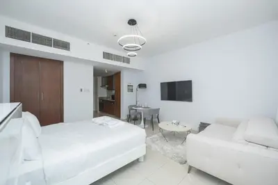 a white bedroom with a bed and a couch at Urban Skyline Haven Near Burj Khalifa in Dubai