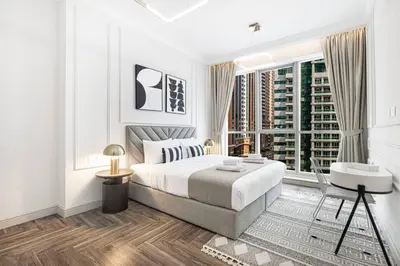 a white bedroom with a bed and a window at StayMada - Torch Tower Marina Walk Gym and Sauna in Dubai