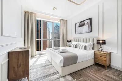 a white bedroom with a large bed and a window at StayMada - Torch Tower Marina Walk Gym and Sauna in Dubai