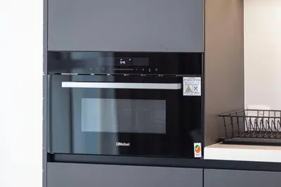 a black oven in a kitchen next to a wall at StayMada - Torch Tower Elegant Marina Retreat in Dubai