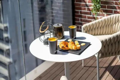 a table with a tray of croissants and two cups of coffee at New 1BR with Rooftop Pool and Amazing View in Dubai